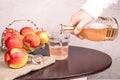 A woman's hand pours apple cider vinegar into glasses.