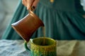 A woman`s hand pours coffee brewed in Turk.Rustic simplicity.