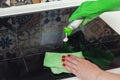 A woman`s hand pours detergent onto the surface of an induction hob