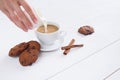 A woman`s hand pours milk into coffee.