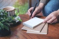 A woman`s hand preparing to write on blank notebook