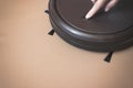 A woman`s hand presses a button Robot Vacuum Cleaner. Close Up. Indoor, housework