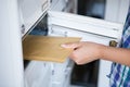 Woman's hand pulling envelop from mailbox