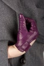 Woman`s hand in purple leather glove and grey woolen coat Royalty Free Stock Photo
