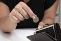 A woman`s hand puts a coin in her wallet. Concept: small pension, poverty, lack of money for living, euro ce Royalty Free Stock Photo