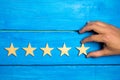 A woman`s hand puts the fifth star. Quality status is five stars