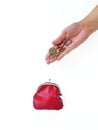 A woman`s hand puts money in a red purse with a metal lock on a white background. Saving money. Royalty Free Stock Photo