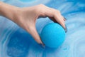 Woman`s hand putting bath bomb into water Royalty Free Stock Photo