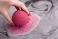 Woman`s hand putting bath bomb into water Royalty Free Stock Photo