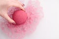 Woman`s hand putting bath bomb into water Royalty Free Stock Photo