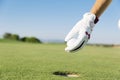 WomanÃÂ´s hand putting a golf ball into hole. Royalty Free Stock Photo