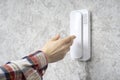 Woman`s hand reaches for the intercom receiver on the wall Royalty Free Stock Photo
