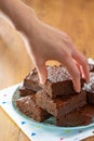 Woman`s Hand Reaching for Homemade Baked Chocolate Brownies