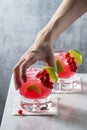 Woman`s Hand Reaching for Red Currant Caipirinha Cocktail