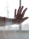 A woman`s hand with a rope that prevents a person from going outside