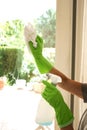 Woman's hand in rubber gloves ckeabubg a window