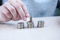 A woman`s hand with a ruble and coins in columns on the table. The concept of accumulation, interest Royalty Free Stock Photo