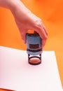 Woman`s hand with the seal, stamp. Process stamping the contract, documents, close up.