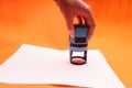 Woman`s hand with the seal, stamp. Process stamping the contract, documents, close up.