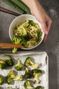 Woman`s hand is serving delicious oriental food, broccoli with spaghetti.