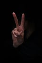 Woman`s hand showing V-sign, victory peace gesture, isolated on black background. Royalty Free Stock Photo