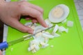 A woman`s hand slices a boiled egg on a salad cutting Board Royalty Free Stock Photo