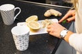 Woman`s hand slicing lemon for tea on dark table Royalty Free Stock Photo