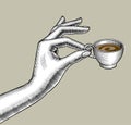 Woman`s hand with a small coffee cup