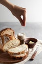 Woman`s hand sprinkling sugar artisan sliced toast bread with butter on wooden cutting board. Simple breakfast Royalty Free Stock Photo