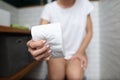 Woman`s hand squeezes roll of toilet paper in toilet close-up