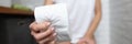 Woman`s hand squeezes roll of toilet paper in toilet close-up