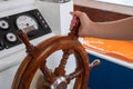 Woman's hand on the steering wheel of the boat. Captain driving powerboat.
