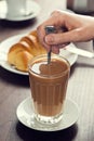 Woman's Hand Stirs a GalÃÂ£o, or Portuguese Latte, with a Spoon