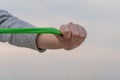 A woman`s hand stretching a green exercise rubber band