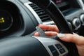 Woman's hand switches the lobes of the gear selector on the steering wheel. Hand is switching car gear lever, close up shot of a Royalty Free Stock Photo