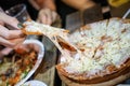 Woman`s hand take pizza pices out from pizza plate in foodtruck event, Cheese`s pizza is stretced by her