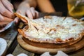 Woman`s hand take pizza pices out from pizza plate in foodtruck event, Cheese`s pizza is stretced by her