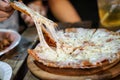 Woman`s hand take pizza pices out from pizza plate in foodtruck event, Cheese`s pizza is stretced by her