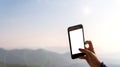 Woman`s hand taking nature pictures with mobile phones.