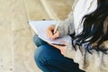 Woman`s hand taking notes in her notebook with pen, sitting Royalty Free Stock Photo