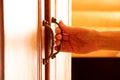 A woman& x27;s hand tears off an old wooden wardrobe, opens the door of a linen closet, a handle on the doors Royalty Free Stock Photo