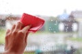 Woman`s hand to wipe drops of water on glass pink fabric. Closeu Royalty Free Stock Photo