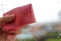 Woman`s hand to wipe drops of water on glass pink fabric. Closeu Royalty Free Stock Photo