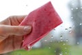 Woman`s hand to wipe drops of water on glass pink fabric. Closeu Royalty Free Stock Photo