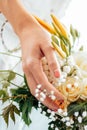 Woman`s hand touches a bouquet of roses and lilies Royalty Free Stock Photo
