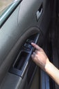 Woman`s hand touches the window adjustment button in the car. Royalty Free Stock Photo