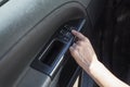 Woman`s hand touches the window adjustment button in the car. Royalty Free Stock Photo