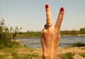 Woman`s hand with two fingers up in the peace or victory symbol. Royalty Free Stock Photo