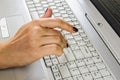 A woman`s hand is typing on a laptop keyboard. Analyze information before pressing the `Enter` button. Royalty Free Stock Photo