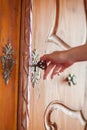 Woman`s hand unlocking a big old, vintage closet